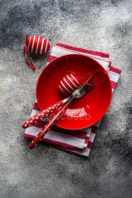 Червоно-біла тарілка з столовими приборами та ножем на темному тлі. вид зверху . — стокове фото