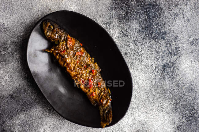 Grilled salmon steak with spices and vegetables on black stone background. top view. — Stock Photo