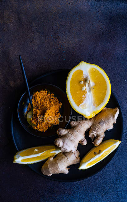 Лимон и имбирь с чесноком на темном фоне — стоковое фото