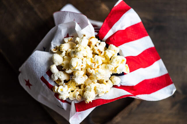 Popcorn in einem Eimer auf einem hölzernen Hintergrund. Ansicht von oben. — Stockfoto
