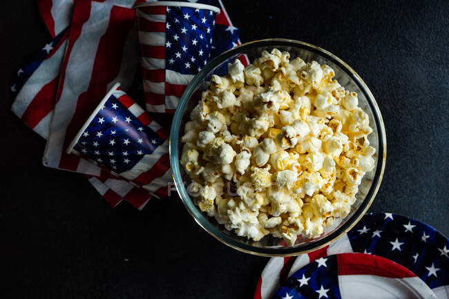 Popcorn and cup of hot dog on a black background. top view. — Stock Photo