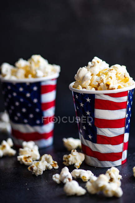 Popcorn und eine Tasse heißen Kaffee auf schwarzem Hintergrund. — Stockfoto