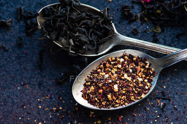 Tè nero in un cucchiaio di legno su uno sfondo scuro — Foto stock