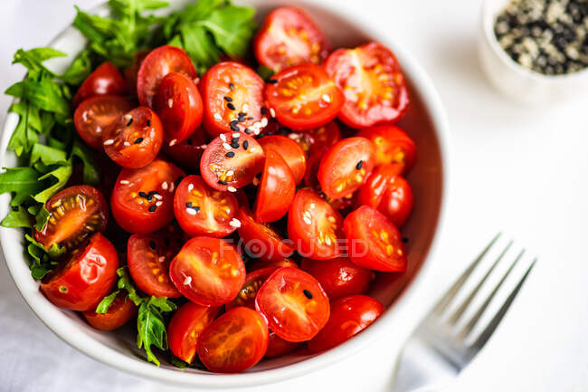 Tomates frescos con tomate y albahaca en un plato - foto de stock
