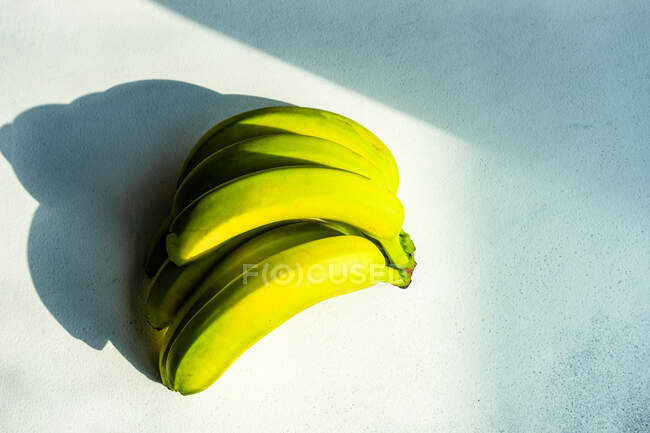 Banana amarela e verde sobre um fundo branco — Fotografia de Stock