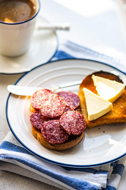 Cup of coffee and toast with cheese and salami — Stock Photo