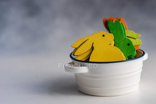 Разноцветные украшения пасхального кролика в керамической миске — стоковое фото
