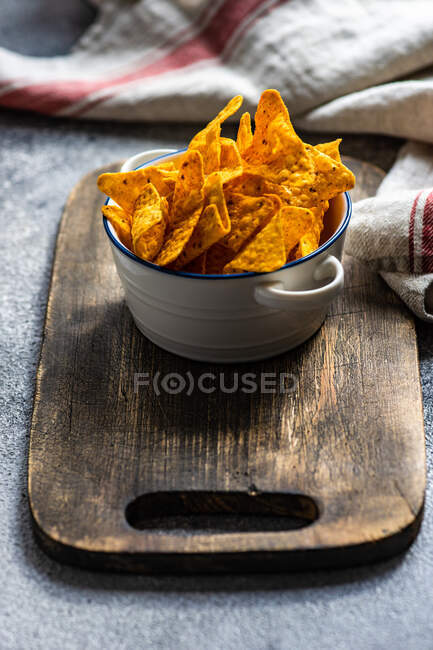 Tazón de papas fritas con salsa en la mesa de madera - foto de stock