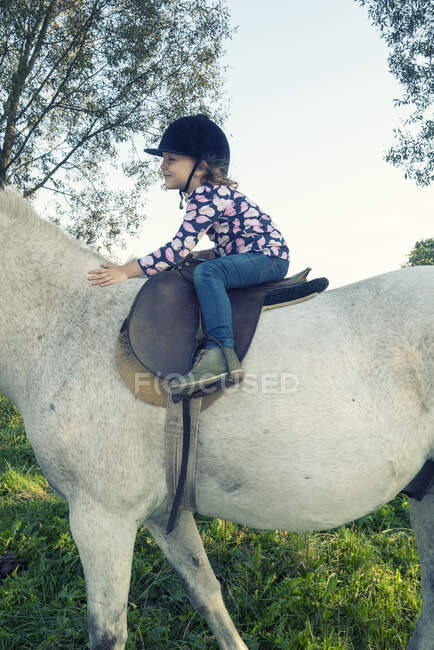 Primer plano de una chica montando un caballo blanco, Polonia - foto de stock