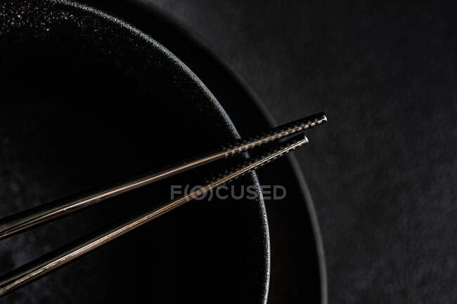 Палочки для еды на черном фоне — стоковое фото