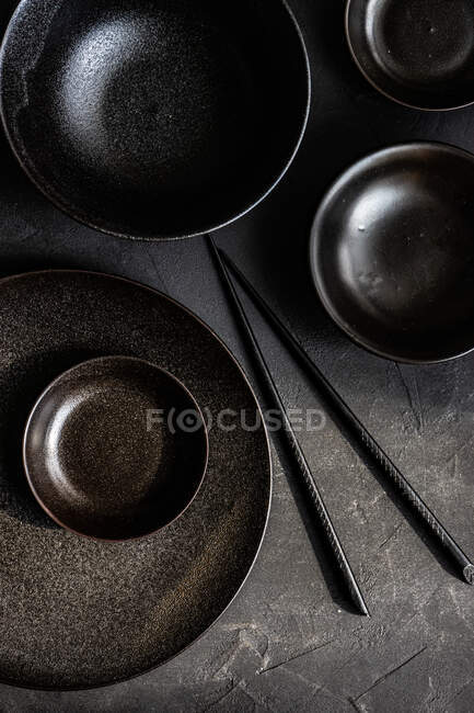 Vista aérea de una mesa asiática con vajilla negra - foto de stock