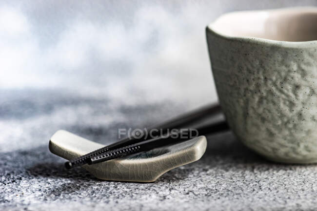 Primer plano de un cuenco de una taza de cerámica blanca y negra sobre un fondo oscuro - foto de stock