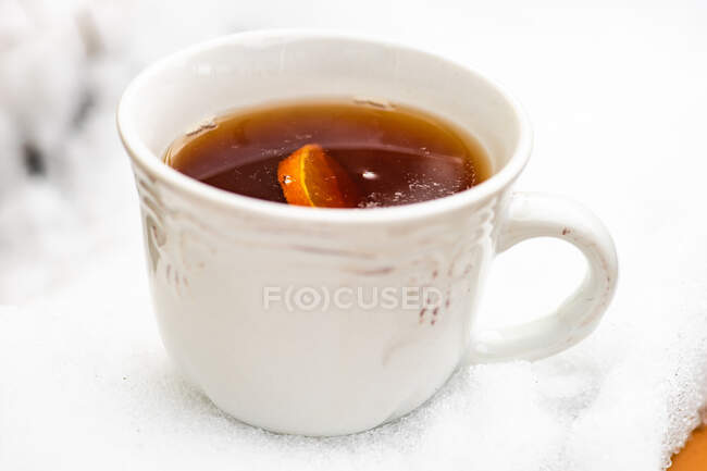 Cup of tea with snow on white background — Stock Photo