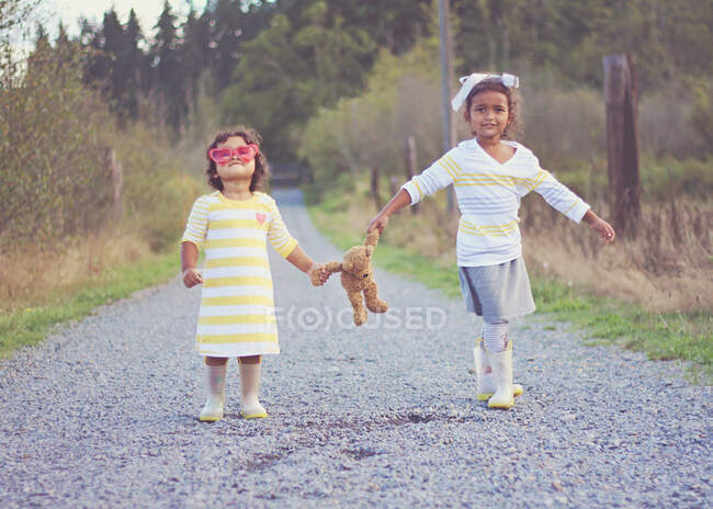 Two girls going for a walk with their teddy bear, Spanaway, Washington, USA — Stock Photo