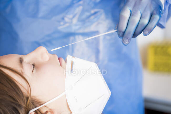 Close-up de um médico realizando um teste de PCR em um menino — Fotografia de Stock