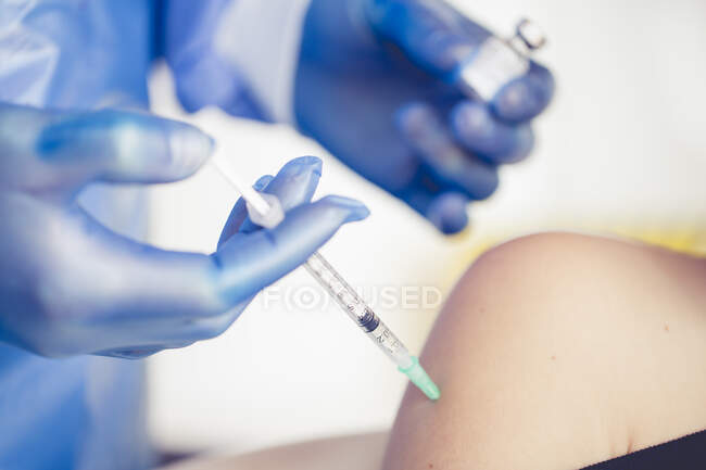 Enfermera vacunando a un niño con la vacuna covid-19 - foto de stock