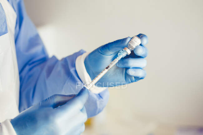 Enfermeira enchendo uma seringa com a vacina coronavírus pronta para vacinar um paciente — Fotografia de Stock
