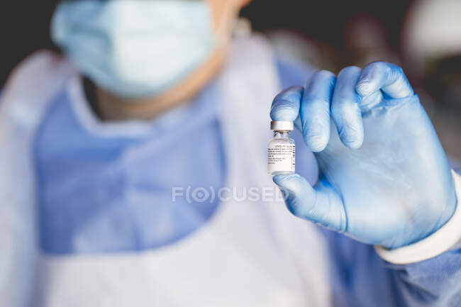Enfermera que sostiene un vial de la vacuna contra el coronavirus - foto de stock