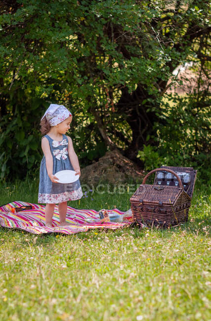 Chica de pie en un parque preparándose para un picnic, Bulgaria - foto de stock