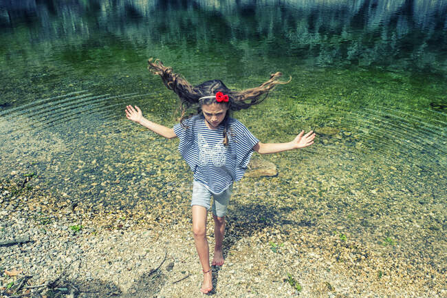 Ragazza che esce da un lago con i capelli spazzati dal vento, Lago di San Domenico, L'Aquila, Abruzzo, Italia — Foto stock