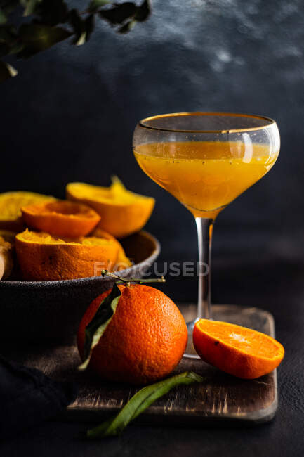 Succo d'arancia fresco con limone e cannella su fondo nero. — Foto stock