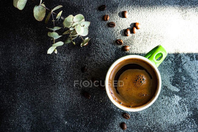Xícara de café com ervas aromáticas frescas no fundo preto — Fotografia de Stock
