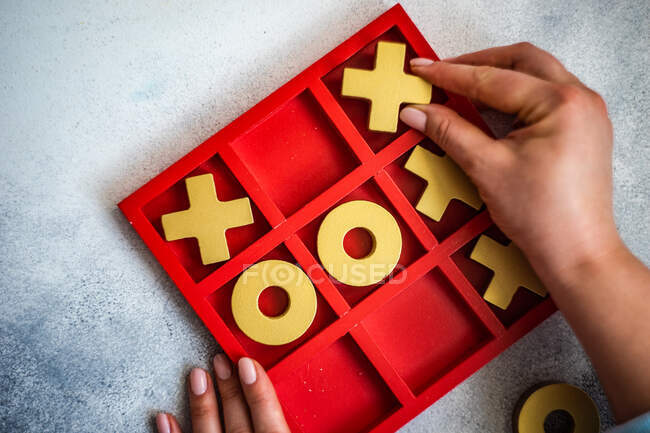 Primer plano de una persona jugando tic tac toe board juego - foto de stock