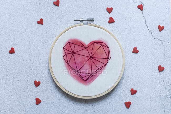 Overhead of embroidery hoop with hearts — Stock Photo