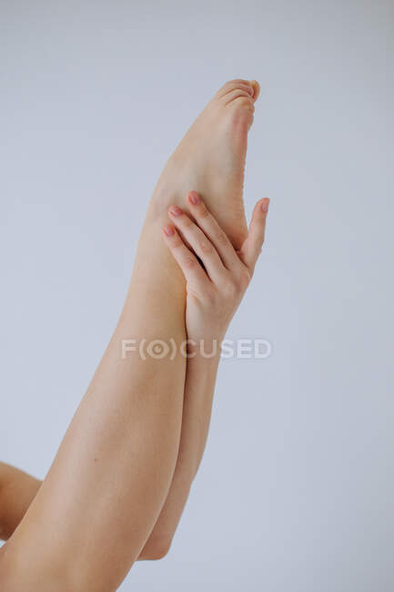 Gros plan d'une femme tenant sa jambe en l'air — Photo de stock
