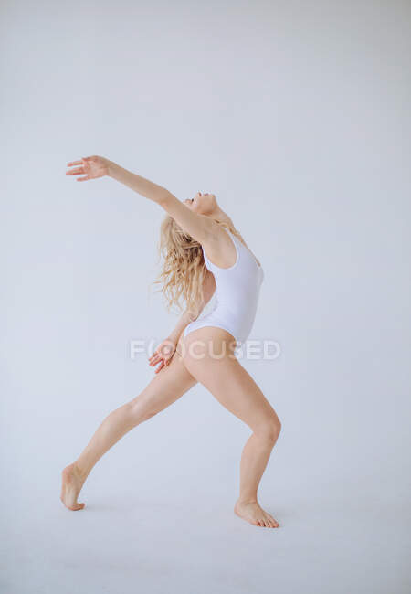 Жінка-гімнастка в білому лейтенанті танцює в студії — стокове фото