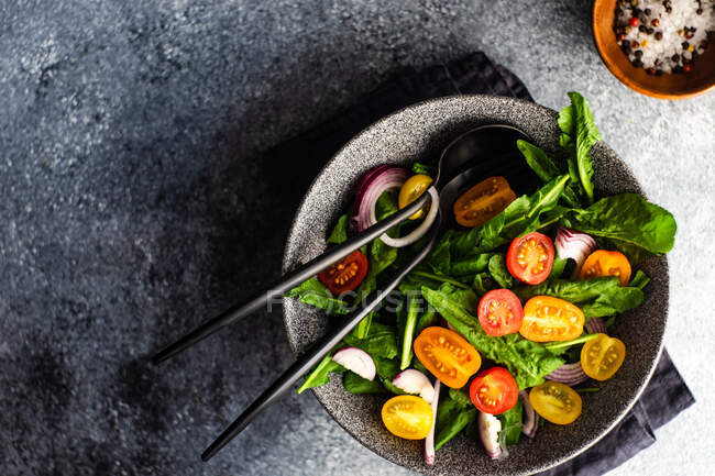 Frischer Salat mit Huhn, Rettich, Avocado, Tomaten, Käse, Basilikum und Tomaten auf schwarzem Hintergrund — Stockfoto