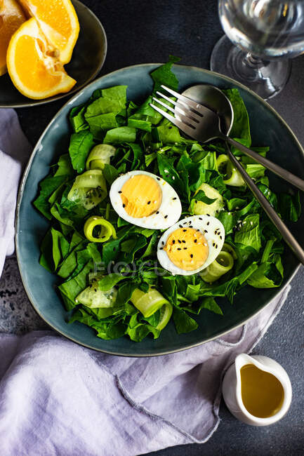Healthy salad with arugula, avocado, spinach, lettuce, cucumber, green onion, black sesame seeds, — Stock Photo
