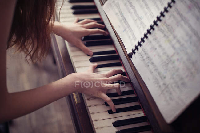 Primer plano de una adolescente tocando el piano - foto de stock