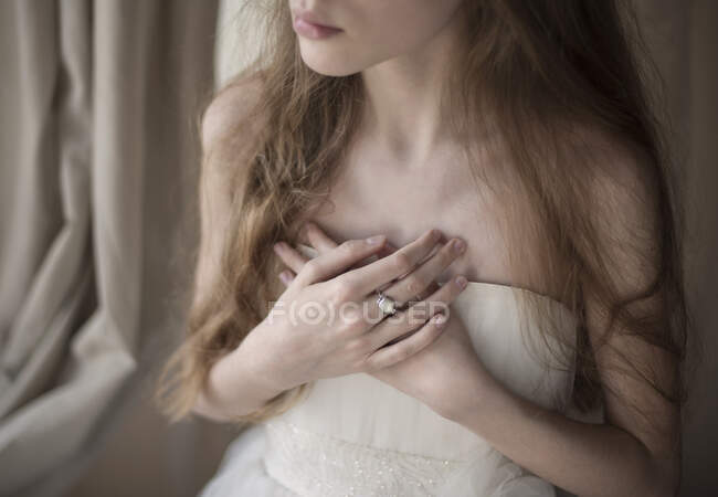 Retrato de uma menina com as mãos dobradas em todo o peito — Fotografia de Stock