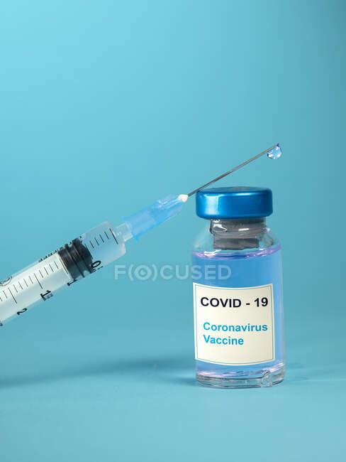 Vacina Covid-19 e seringa numa mesa — Fotografia de Stock