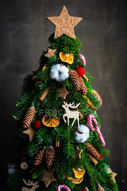 Рождественская елка с украшениями и игрушками на черном фоне — стоковое фото