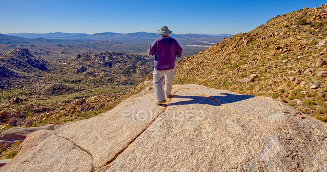 Мандрівник стоїть на скелі і дивиться на краєвид, територію відпочинку Гранітного басейну, Національний ліс Прескотт, штат Арізона, США. — стокове фото
