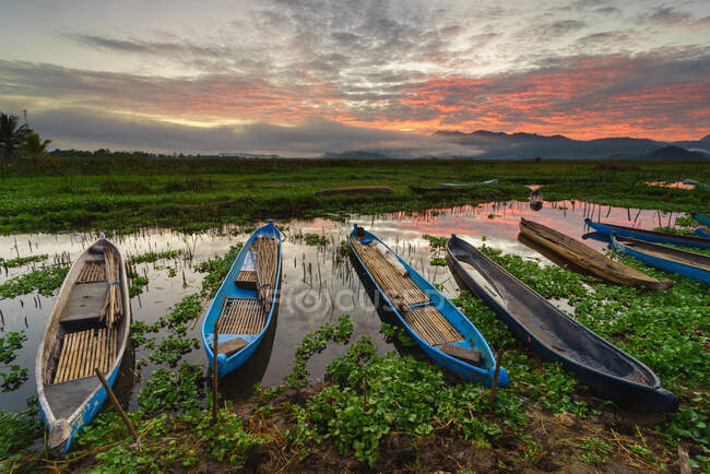 Row of Fishing boats moored on Lebo lake at sunset, Sumbawa, Indonesia — Stock Photo