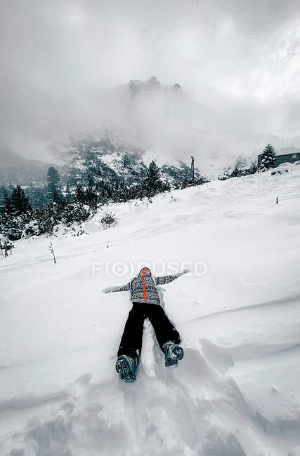 Ragazza felice sdraiata sulla neve in montagna, Rila, Bulgaria — Foto stock