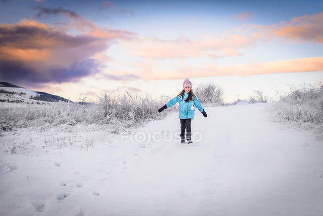 Menina sorridente caminhando pela paisagem de inverno ao pôr do sol, Rila, Bulgária — Fotografia de Stock