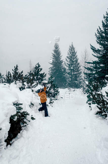 Junge wirft einen Schneeball in die Luft, Bulgarien — Stockfoto