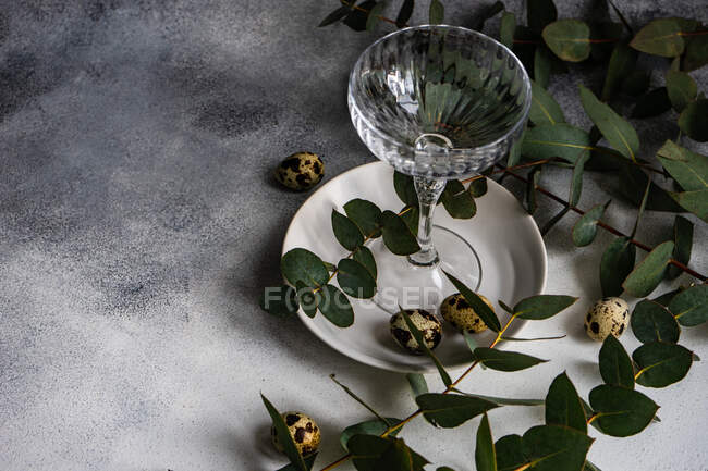 Пасхальный стол с пасхальными яйцами и стеблями эвкалипта — стоковое фото