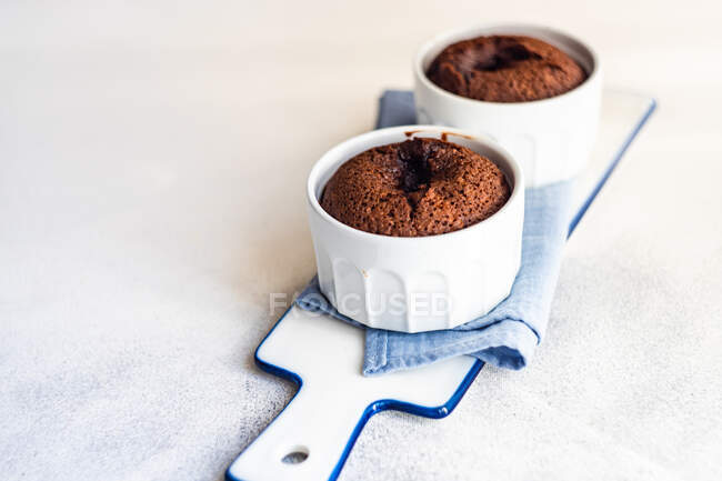 Two individual chocolate fondant cakes on a serving board — Stock Photo