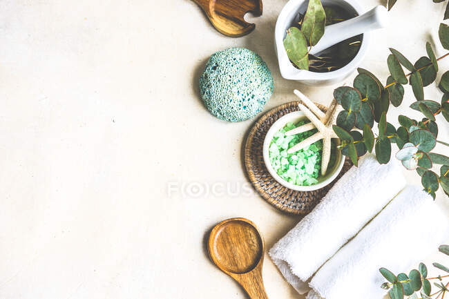 Bath salts, fresh eucalyptus, sponge and towel wellbeing arrangement — Stock Photo