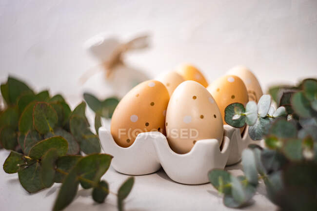 Ovos de Páscoa com um coelho de Páscoa e caules de eucalipto — Fotografia de Stock