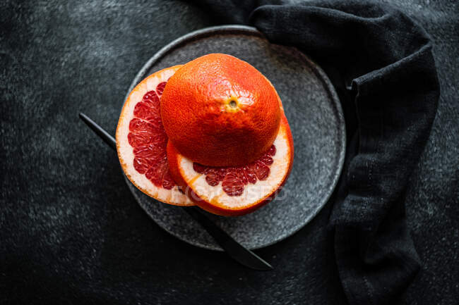 Slices of pink grapefruit on a stone plate — Stock Photo
