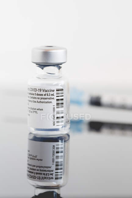 Un flacon du vaccin contre le coronavirus et une seringue sur une table dans une clinique — Photo de stock