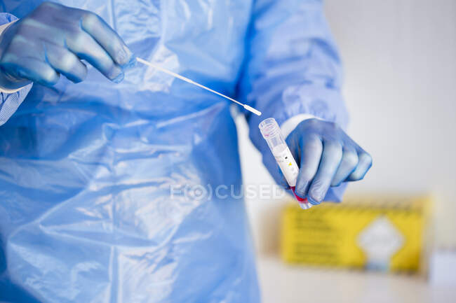 Gros plan d'un médecin qui met un tampon test PCR dans un tube — Photo de stock