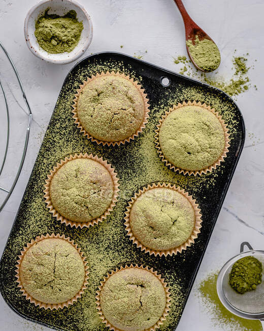 Overhead view of a tray of Matcha muffins sprinkled with matcha powder — Stock Photo