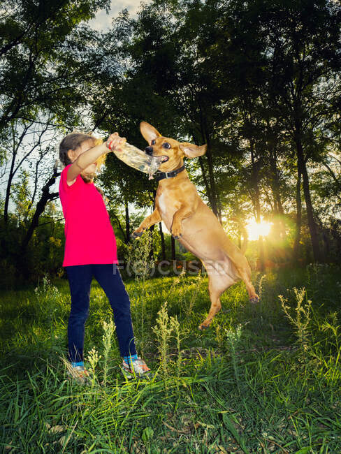 Girl playing with her dog in the park, Italy — Stock Photo